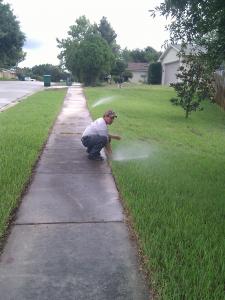 a Garland Sprinkler Repair contractor checks a sprinkler head